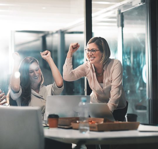 Shot of colleagues celebrating during a meeting in a modern office